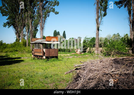 CERTOSA di Pavia, Italien - 30 April, 2019: eine alte rostige Straßenbahn-Wagen legt auf den Garten von Certosa di Pavia, das Kloster verlassen. Stockfoto