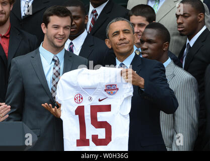 Us-Präsident Barack Obama hält bis ein Alabama Football Jersey, die ihm von Alabama Quarterback AJ McCarron vorgestellt wurde (Licht im blauen Hemd) während der Zeremonien zu Ehren der Crimson Tide wie der BCS College nationale Meisterschaften auf dem Rasen des Weißen Hauses am 15. April 2013. UPI/Pat Benic Stockfoto