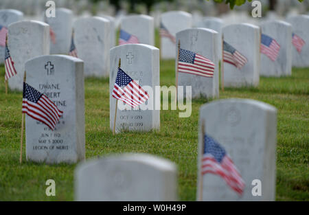 American Flags sind vor einem grabsteine während der jährlichen Flags-In Zeremonie gesehen, 23. Mai 2013, auf dem Arlington National Cemetery in Arlington, Virginia. Soldaten, amerikanische Flaggen vor mehr als 260.000 Grabsteine auf dem Friedhof zu Ehren der Memorial Day. UPI/Kevin Dietsch Stockfoto