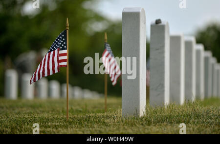 American Flags sind vor einem grabsteine während der jährlichen Flags-In Zeremonie gesehen, 23. Mai 2013, auf dem Arlington National Cemetery in Arlington, Virginia. Soldaten, amerikanische Flaggen vor mehr als 260.000 Grabsteine auf dem Friedhof zu Ehren der Memorial Day. UPI/Kevin Dietsch Stockfoto