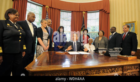 US-Präsident Barack Obama macht Anmerkungen, bevor er Zeichen eines Wechsels im Oval Office, 24. Mai 2013 in Washington, DC, die Benennung der Congressional Gold Medal zum Gedenken an das Leben der vier jungen Mädchen in der 16th Street Baptist Church Bombardierungen von 1963 in Birmingham, Alabama getötet. Zeugen (L-R) Surgeon General Regina Benjamin, Birmingham Bürgermeister William Bell, Dr Sharon Malone Halter, Justizminister Eric Holder, Rep Terri Sewell (D-AL), Thelma Pippen McNair (Mutter von Denise McNair), Lisa McNair (Schwester von Denise McNair), Dianne Braddock (Schwester von Carole Robertson), Rev Arthur Preis, Jr Stockfoto