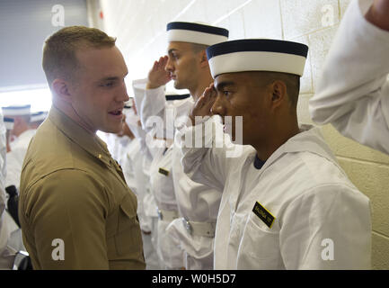 Ein U.S. Marine Corps 2. Lt korrigiert ein Plebes salute während der Induktion Tag an der US Naval Academy am 27. Juni in Annapolis, Maryland, 2013. Die Klasse von 2017 an der Marineakademie kamen ihre Sommer Ausbildung, die die Grundlage der Akademie die vier Laien-Jahr-professionellen Lehrplan zu beginnen. UPI/Kevin Dietsch Stockfoto