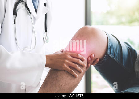 Arzt prüfen Patienten mit Knie, um die Ursache der Krankheit bestimmen. Stockfoto