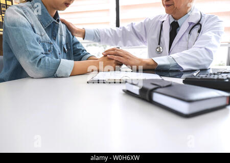 Arzt in Unterstützung und Trost im Gespräch mit Patienten und halten x-ray film bei der Diskussion erklären, Symptome oder Rat Diagnose hea Stockfoto