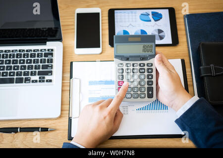 Geschäftsmann mit Text Informationen zum digitalen Tablet finanzielle statistische Daten zu analysieren und die Kosten des Investitionsvorhabens berechnen. Stockfoto