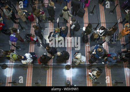 Reisende warten in Linie an einem TSA Security Checkpoint am nationalen Flughafen Ronald Reagan, 26. November 2013 in Arlington, Virginia. Schwere Unwetter, von dem erwartet wird, dass der Großteil des Landes in den nächsten zwei Tagen zu beeinflussen, hat das Potential, massive Verzögerungen für die Urlauber zu verursachen. UPI/Kevin Dietsch Stockfoto