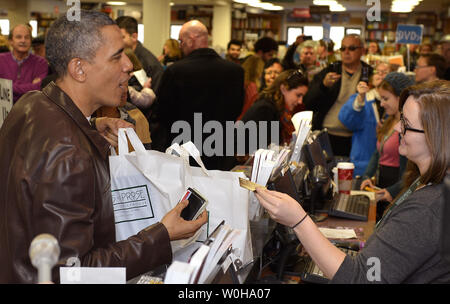 US-Präsident Barack Obama seine Kreditkarte nach seiner Käufe bei einem Einkaufsbummel durch die unabhängige Buchhandlung Politik & Prosa, November 30, 2013, in Washington, DC. Das Shoppen fiel mit Small Business Samstag, eine Tradition, die Shopping für kleinere Kaufleute zu erhöhen. UPI/Mike Theiler Stockfoto