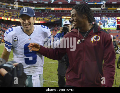 Cowboys Quarterback Tony Romo (L) gratuliert durch Washington Redskins Quarterback Robert Greif III, die nicht wegen einer Verletzung spielen, nach Romo fuhren die Cowboys, die das Feld in den späten 4. Quartal für eine gekommen - von - hinter Gewinn, 24-23, bei FedEx Feld in Landover, Maryland am 22. Dezember 2013. UPI/Mike Theiler Stockfoto