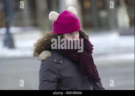 Eine Frau, die sich selbst schützt vor Wind und Kälte in Washington, D.C., 22. Januar 2014. Die Temperaturen an der Ostküste sind im Zuge eines arktischen Luftmasse eingebrochen. UPI/Kevin Dietsch Stockfoto