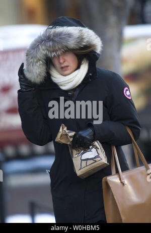 Eine Frau, die sich selbst schützt vor Wind und Kälte in Washington, D.C., 22. Januar 2014. Die Temperaturen an der Ostküste sind im Zuge eines arktischen Luftmasse eingebrochen. UPI/Kevin Dietsch Stockfoto