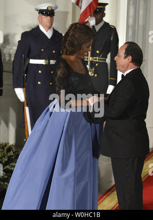 Der französische Präsident Francois Hollande (R) hält die Hände mit der First Lady Michelle Obama, als er an das Weiße Haus für ein Abendessen, 11. Februar 2014, in Washington, DC, begrüßt wird. Hollande ist auf Staatsbesuch bilateralen Handel zu stärken, wirtschaftliche und sicherheitspolitische Beziehungen. UPI/Mike Theiler Stockfoto