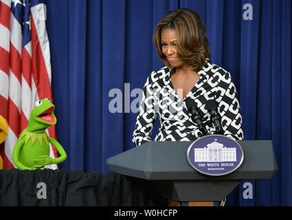 First Lady Michelle Obama und Kermit der Erläuterungen liefern vor einem Film Screening von 'Muppets Most Wanted' für Kinder von militärischen Familien an den Eisenhower Executive Office Building in Washington, DC, 12. März 2014. UPI/Kevin Dietsch Stockfoto