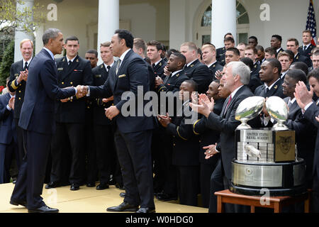 Präsident Barack Obama gratuliert Marine Haupttrainer Ken Niumatalolo, als er die Hände schüttelt mit dem Spieler und Mitarbeiter nach Vorlage des Commander-In-Chief Trophäe an die Naval Academy Football Team im Rosengarten des Weißen Hauses in Washington, DC am 18. April 2014. Obama sagte, dass die Spieler Engagement für ihr Land mehr Spezielle war ihr ihre Fußballmannschaft. UPI/Pat Benic Stockfoto