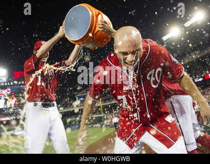 Washington Angehörigen linker Feldspieler Scott Hairston getaucht wird durch Mannschaftskameraden Jerry Blevins (L) und Craig stammen, nach Hairston das Spiel hit-winning scarifies fliegen, so dass Jayson Werth zu zählen, im elften Inning gegen die Pittsburgh Pirates an den Angehörigen Park am 17. August 2104 in Washington, D.C. Die Angehörigen die Piraten 6-5 besiegt. UPI/Kevin Dietsch Stockfoto