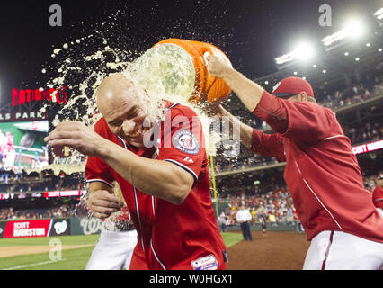 Washington Angehörigen linker Feldspieler Scott Hairston getaucht wird durch Mannschaftskameraden Jerry Blevins (L) und Craig stammen, nach Hairston das Spiel hit-winning scarifies fliegen, so dass Jayson Werth zu zählen, im elften Inning gegen die Pittsburgh Pirates an den Angehörigen Park am 17. August 2104 in Washington, D.C. Die Angehörigen die Piraten 6-5 besiegt. UPI/Kevin Dietsch Stockfoto