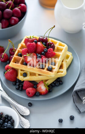 Hausgemachten belgischen Waffeln mit Beeren auf grau Tabelle. Gesundes Frühstück Konzept. Stockfoto