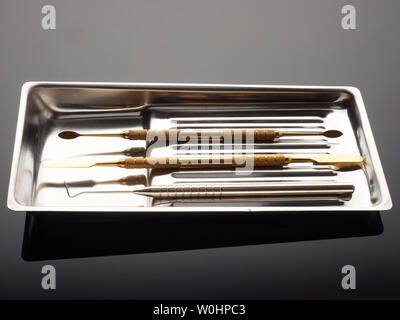 Medizinische Instrumente in einer zahnmedizinischen Fach auf einem grauen Hintergrund Farbverlauf Stockfoto