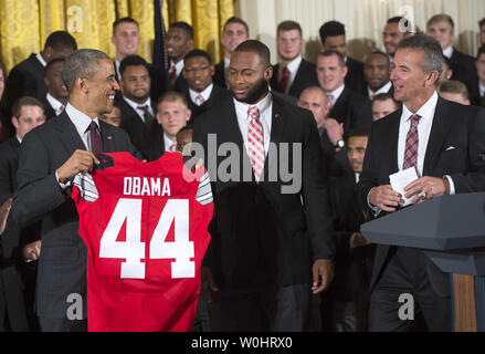 Präsident Barack Obama erhält ein Jersey von Ohio State Roßkastanie-Team Captain Curtis gewähren wie Obama ehrt den 2015 College Football Endspiel nationalen Meister Ohio State University Roßkastanien im Osten Zimmer im Weißen Haus in Washington, D.C. am 20. April 2015. Foto von Kevin Dietsch/UPI Stockfoto