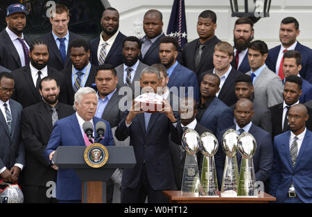 Us-Präsident Barack Obama (C) hält ein Souvenir Fußball als Mannschaft Eigentümer Robert Kraft (L) macht die Erläuterungen, wie Sie von der NFL Super Bowl Champion New England Patriots während der Begrüßungszeremonie auf dem Rasen des Weißen Hauses, April 23,2015, in Washington, DC, verbunden sind. Die Patrioten schlugen die Seattle Seahawks, 28-24, in einem spannenden Super Bowl XLIX früh dieses Jahr, für ihren vierten Trophäe. Foto von Mike Theiler/UPI Stockfoto