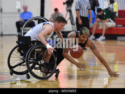 Team Luftwaffe Zachary Burnash kämpft für den ball als Team Armee Dustin Barr von seinem Stuhl während der Rollstuhl Basketball Bronzemedaille Spiel gegen Team Armee fällt, in der Abteilung 2015 der Verteidigung Krieger Spiele bei dem United States Marine Corps in Quantico, Virginia, 22. Juni 2015. Foto von Molly Riley/UPI Stockfoto