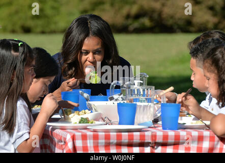 First Lady Michelle Obama isst Salat mit lokalen Bereich Schule Kinder im Herbst Garten Ernte im Weißen Haus Garten, in Washington, D.C. am 6. Oktober 2015. Die erste Dame investiert Kinder von vier lokalen Grundschulen aus dem Garten ernten zu beteiligen und Lear über gesunde Ernährung. Foto von Kevin Dietsch/UPI Stockfoto