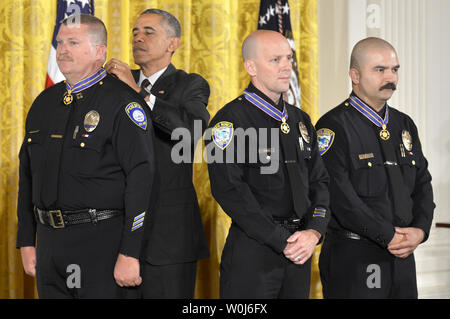 Us-Präsident Barack Obama (2., L) eine Medaille von Valor um den Hals von Captain Raymond Bottenfield (L), nach Auftragsvergabe Officer Jason Salas (R) und Officer Robert Funken, alle von Santa Monica, Kalifornien, ihre Auszeichnungen im Rahmen einer Feierstunde im East Room des Weißen Hauses, 16. Mai 2016 in Washington, DC. Die Ehre ist für die öffentliche Sicherheit Offiziere, die außergewöhnlichen Mut bei der Ausübung ihrer Tätigkeit anzuzeigen. Foto von Mike Theiler/UPI Stockfoto