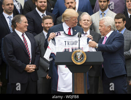 Präsident Donald Trump hält eine benutzerdefinierte Jersey, die er von New England Patriots Inhaber Robert Kraft (R), als Patrioten coach Bill Belichick (L) Uhren, während der Zeremonie, an der Trumpf der Super Bowl LI Champions New England Patriots geehrt im Weißen Haus in Washington, D.C. am 19. April 2017. Mindestens 7 Spieler, einschließlich Quarterback Tom Brady, übersprang die besuchen, der auf den Tag der ehemaligen Patriot festes Ende selbst im Gefängnis, während Sie einen Lebensatz für Mord. Foto von Kevin Dietsch/UPI Stockfoto