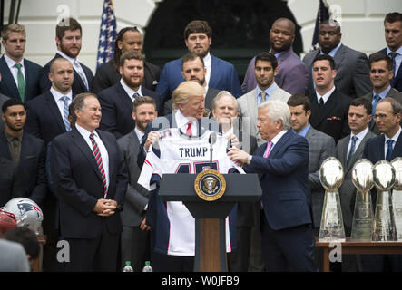 Präsident Donald Trump hält eine benutzerdefinierte Jersey, die er von New England Patriots Inhaber Robert Kraft (R), als Patrioten coach Bill Belichick (L) Uhren, während der Zeremonie, an der Trumpf der Super Bowl LI Champions New England Patriots geehrt im Weißen Haus in Washington, D.C. am 19. April 2017. Mindestens 7 Spieler, einschließlich Quarterback Tom Brady, übersprang die besuchen, der auf den Tag der ehemaligen Patriot festes Ende selbst im Gefängnis, während Sie einen Lebensatz für Mord. Foto von Kevin Dietsch/UPI Stockfoto