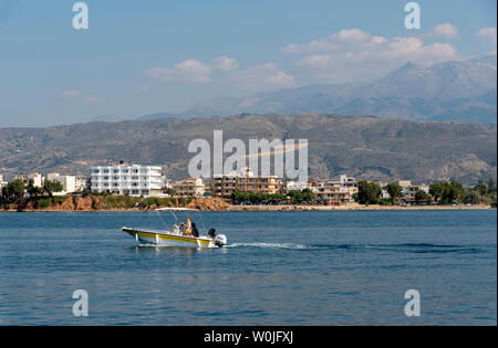 Chania, Kreta, Griechenland. Juni 2019. Junges Paar Bootsfahrten entlang der Küste Landschaft des nördlichen Chania Kreta, Hotels und Wohnungen mit einem Hintergrund o Stockfoto