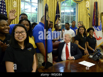 Präsident Donald Trump begrüßt Schulkinder von Sieg Christliches Zentrum Schule von Charlotte, North Carolina, im Oval Office, die eine Rakete während eines Wettbewerbs, dem sie den Namen 'Trumpf', saß auf seinem Schreibtisch (C) im Weißen Haus, 12. Mai 2017 in Washington, DC ausgelegt haben. Foto von Mike Theiler/UPI Stockfoto