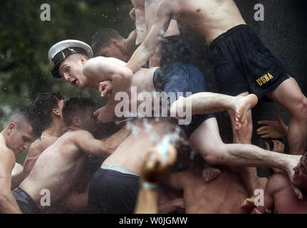 Ein midshipman fällt während der jährlichen Herndon Monument, Klettern an der United States Naval Academy in Annapolis, Maryland, am 22. Mai 2017. Midshipman Joe McGraw, Rockford, Illinois, Upperclassman hat oben auf dem Denkmal nach 2 Stunden, 21 Minuten und 21 Sekunden. Der Herndon Denkmal Klettern ist die traditionelle Höhepunkt des plebe oder im ersten Jahr, an der U.S. Naval Academy. Die Klasse muss gemeinsam ein White plebs abzurufen 'Dixie Cup' Hut des Denkmals und es mit einem Upperclassman hat austauschen. Foto von Kevin Dietsch/UPI Stockfoto