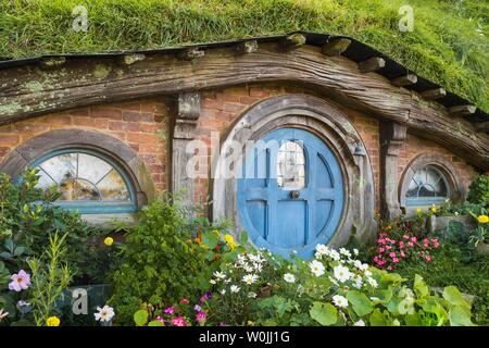 Hobbit Höhle mit blauer Tür, Hobbiton im Auenland, Standort für Herr der Ringe und der Hobbit Matamata, Waikato, North Island, Neuseeland Stockfoto