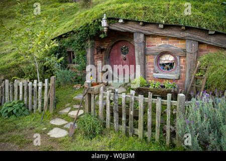 Hobbit Höhle mit Red Door, Hobbiton im Auenland, Standort für Herr der Ringe und der Hobbit Matamata, Waikato, North Island, Neuseeland Stockfoto