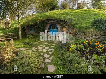 Hobbit Höhle mit blauer Tür, Hobbiton im Auenland, Standort für Herr der Ringe und der Hobbit Matamata, Waikato, North Island, Neuseeland Stockfoto