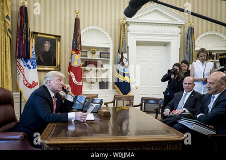 U.S. National Security Advisor H.R. McMaster und Chief wirtschaftlichen Berater Gary Cohn (Rechts) Blick auf als Präsident Donald Trump spricht mit Premierminister Leo Varadkar von Irland per Telefon im Oval Office im Weißen Haus am 27. Juni 2017 in Washington, DC. Trump, der Aufruf, den neu gewählten Ministerpräsidenten und derzeitigen Taoiseach gratulieren. Der Führer der Fine Gael Partei, Varadkar wurde nach dem Ausscheiden von Enda Kenny gewählt. Foto von Pete Marovich/UPI Stockfoto