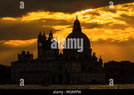 Geheimnisvoll und beautiufl Sonnenuntergang über Salute Basilika (Saint Mary für Gesundheit) alten Kuppeln in Venedig Stockfoto