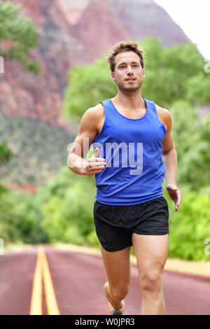 Sport und Fitness runner Mann laufen auf der Straße Training für Marathon laufen tun sprint Intervall Training im Freien im Sommer. Männliche Athlet Sport Modell fit und gesund lächelnd mit Ambitionen. Stockfoto
