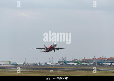 DENPASAR, Bali/Indonesien - Juni 08 2019: Air Asia Flugzeug (Airbus) ist vom internationalen Flughafen Ngurah Rai Bali Landebahn, wenn der Himmel Stockfoto