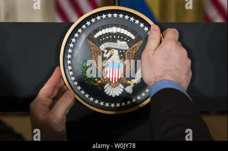 Eine Hilfe stellt die Presidential Seal auf dem Podium vor einer gemeinsamen Pressekonferenz zwischen Präsident Donald J. Trumpf und Ministerpräsident Stefan Lofven von Schweden, im Weißen Haus in Washington, D.C. am 6. März 2018. Foto von Kevin Dietsch/UPI Stockfoto