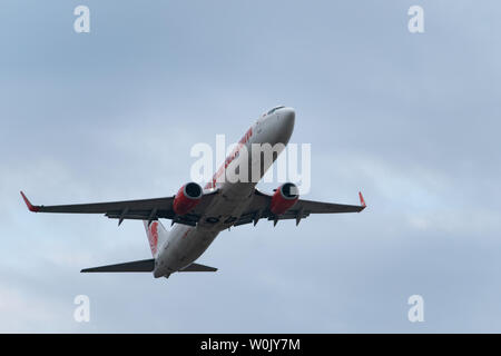 DENPASAR, Bali/Indonesien - Juni 08 2019: Lion Air Flugzeug fliegt vom internationalen Flughafen Ngurah Rai Bali, wenn der Himmel ist bewölkt, grau Stockfoto