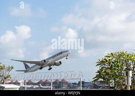 DENPASAR, Bali/Indonesien - Juni 08 2019: Katar airline Flugzeug fliegt vom internationalen Flughafen Ngurah Rai Bali, wenn der Himmel bewölkt ist grau, mit Stockfoto