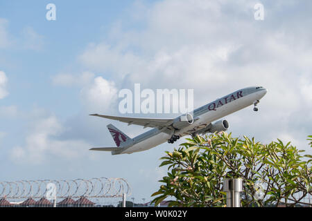 DENPASAR, Bali/Indonesien - Juni 08 2019: Katar airline Flugzeug fliegt vom internationalen Flughafen Ngurah Rai Bali, wenn der Himmel bewölkt ist grau, mit Stockfoto