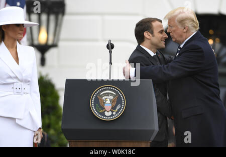 Präsident Donald Trump (R) und der französische Präsident Emmanuel Längestrich Umarmung als First Lady Melania Trump steht am Ende der Staatsbesuch Begrüßung im Weißen Haus, April 24,2018, in Washington, DC. Die Staats- und Regierungschefs erwartet werden, den Handel, den Iran, den Klimawandel zu diskutieren, Nordkorea, Russland unter anderem. Foto von Mike Theiler/UPI Stockfoto