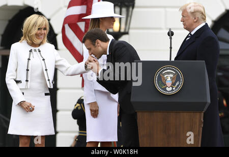 Der französische Präsident Emmanuel Längestrich küsse die Hand seiner Frau Brigitte als Präsident Donald Trump (R) und die erste Dame Melania Trump stehen am Ende der Staatsbesuch Begrüßung, im Weißen Haus, April 24, 2018, in Washington, DC. Die Staats- und Regierungschefs erwartet werden, den Handel, den Iran, den Klimawandel zu diskutieren, Nordkorea, Russland unter anderem. Foto von Mike Theiler/UPI Stockfoto