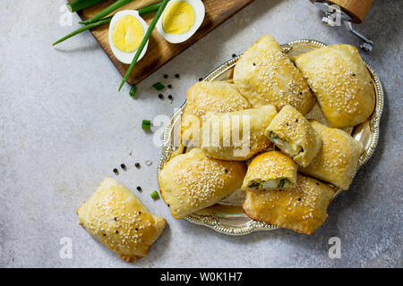 Traditionelle russische Küche. Torten Ei und grüne Zwiebeln auf Licht Tisch aus Stein. Ansicht von oben flach. Stockfoto