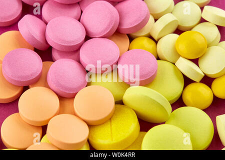 Nahaufnahme von vielen rosa, gelb und orange Pillen. Stockfoto