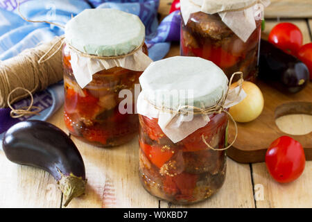 Hausgemachte bewahren. Auberginen Salat mit Gemüse in der Küche Holz- Hintergrund. Stockfoto
