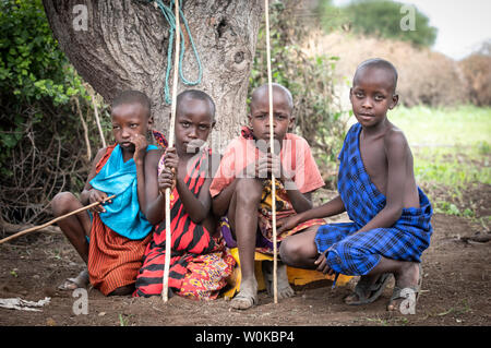 Gleichen, Tansania, 5. Juni 2019: junge Maasai jungen Rast unter einem Baum Stockfoto