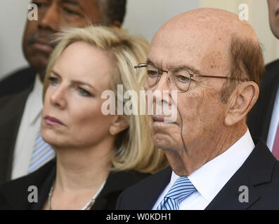 Verwaltung Beamte Präsident Donald Trump DHS Secretary Kirstjen Nielsen (L) und Commerce Secretary Wilbur Ross hören seine Erläuterungen im Rosengarten des Weißen Hauses, Washington, DC, 25. Januar 2019. Trump kündigte die Verwaltung Vereinbarung zum erneuten Öffnen der Regierung bis Mitte Februar, als die Verhandlungen über die Sicherheit der Grenzen erreicht hat. Foto von Mike Theiler/UPI Stockfoto