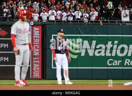 Philadelphia Phillies rechter Feldspieler Bryce Harper steht an der zweiten Base (L) als Gruppe von Washington Nationals fans Hemden tragen, buchstabieren, 'Verräter, da die Phillies die Angehörigen an den Angehörigen spielen am 2. April 2019 in Washington, D.C., ist Harper's erstmals wieder seit dem Verlassen der Nationals Park für die Phillies. Foto von Kevin Dietsch/UPI Stockfoto